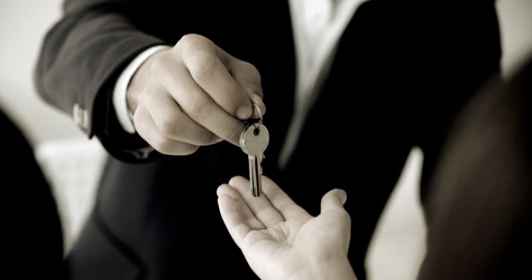 a man handing over a key