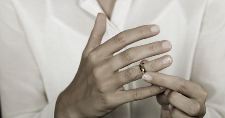 a lady removing her wedding ring